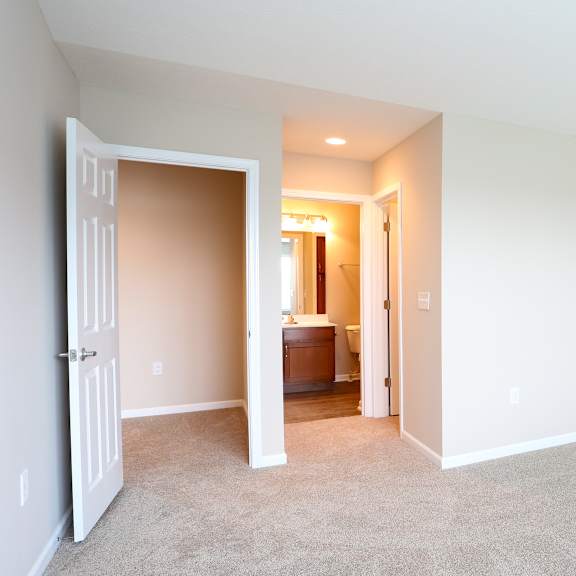 a room with carpet and a door to a bathroom
