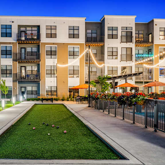 an exterior view of an apartment building with a grassy courtyard