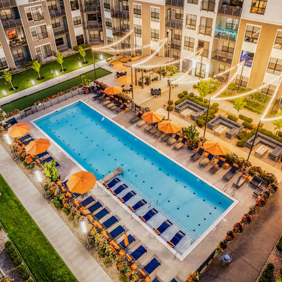 an overhead view of a swimming pool in front of an apartment building