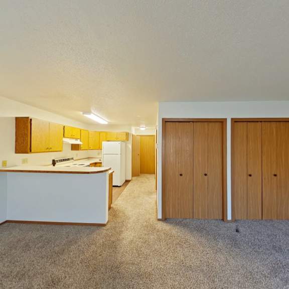 Thumbnail 7 of 10 A room with a white counter and brown cupboards.