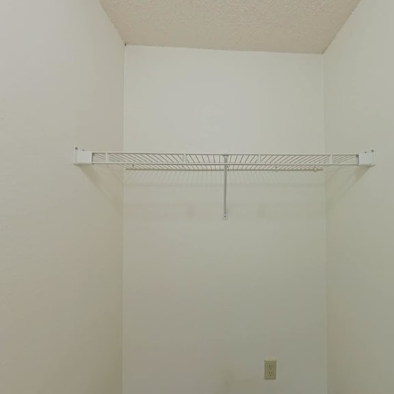 Thumbnail 9 of 10 A white wall with a metal shelf attached to it.