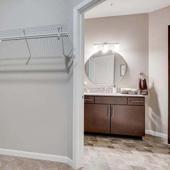 Thumbnail 8 of 10 a closet in a bathroom with a sink and a mirror. Circle Pines, MN Lexington Lofts