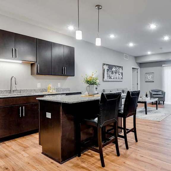 Thumbnail 3 of 10 a kitchen and dining room with a table and chairs. Circle Pines, MN Lexington Lofts