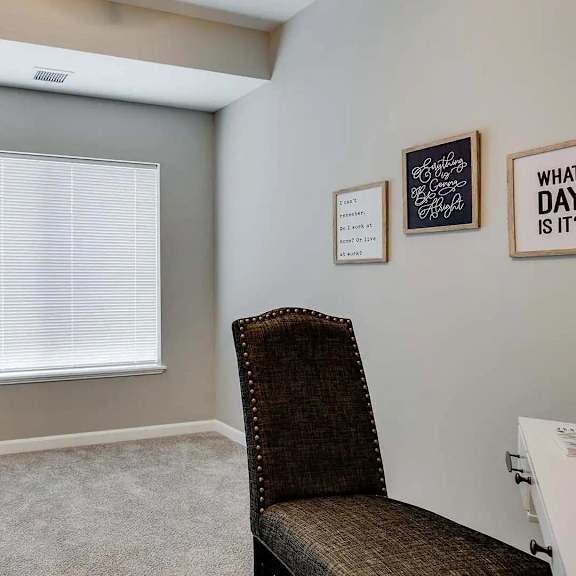 Thumbnail 11 of 12 a living room with a chair and a window and a door.  Circle Pines, MN Lexington Lofts