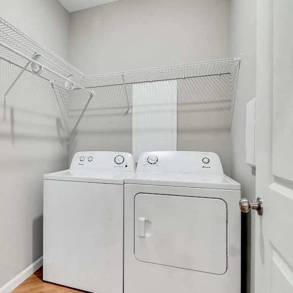 Thumbnail 12 of 12 a washer and dryer in a laundry room with a rack on the wall Lexington Lofts