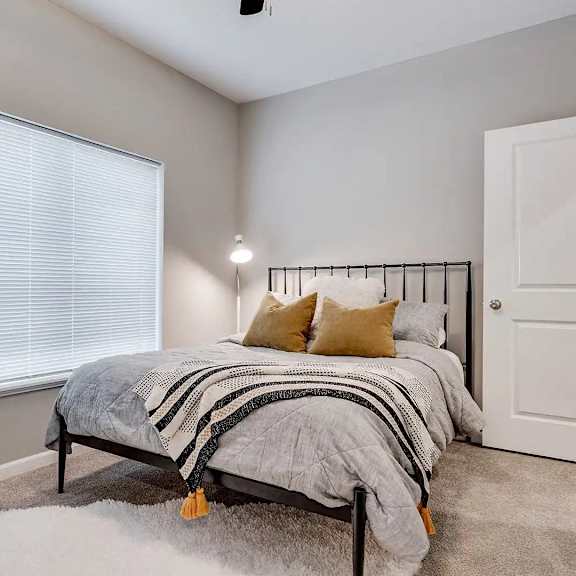Thumbnail 6 of 11 a bedroom with a bed next to a window. Circle Pines, MN Lexington Lofts