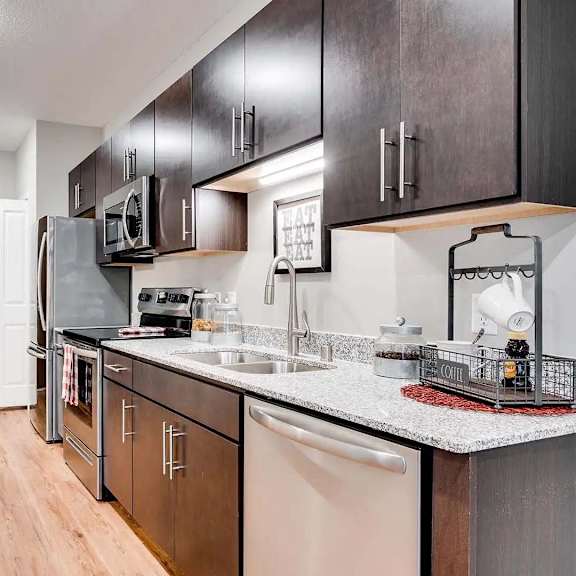 Thumbnail 3 of 7 a kitchen with a counter top and a sink. Circle Pines, MN Lexington Lofts