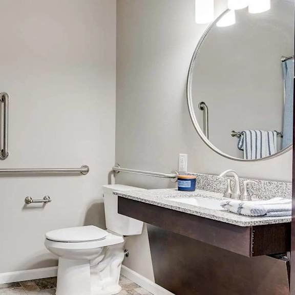 Thumbnail 5 of 6 a bathroom with a toilet and a sink and a mirror. Circle Pines, MN Lexington Lofts