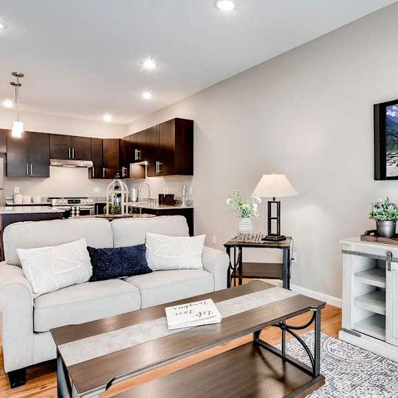 Thumbnail 3 of 6 a living room and kitchen with a couch and a table. Circle Pines, MN Lexington Lofts
