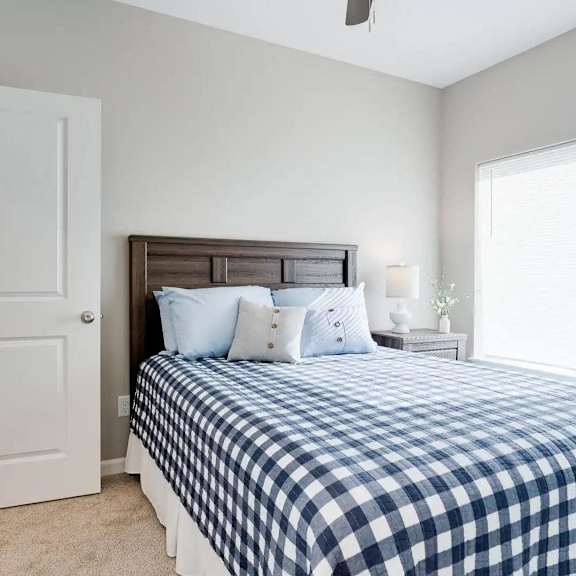 Thumbnail 6 of 8 a bedroom with a bed and a large window. Circle Pines, MN Lexington Lofts