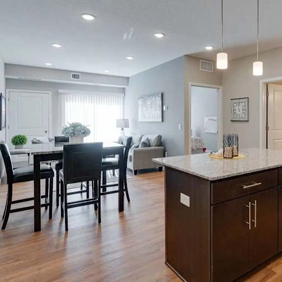 Thumbnail 3 of 8 an open kitchen and dining room with a table and chairs. Circle Pines, MN Lexington Lofts