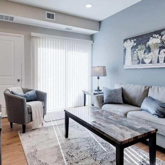 Thumbnail 5 of 8 a living room with a couch and a table. Circle Pines, MN Lexington Lofts