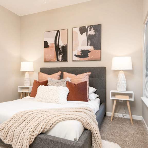 Thumbnail 5 of 6 a bedroom with a bed and paintings on the wall. Circle Pines, MN Lexington Lofts