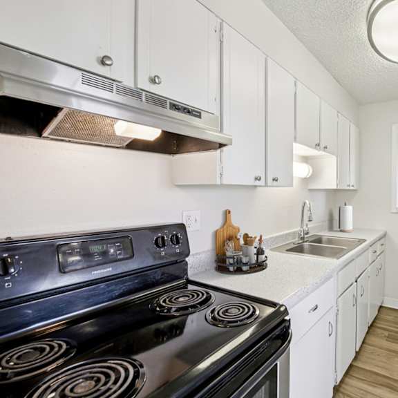 a kitchen with a black stove top oven and white cabinets.