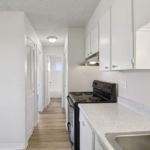 a kitchen with white cabinets and a black stove top oven.