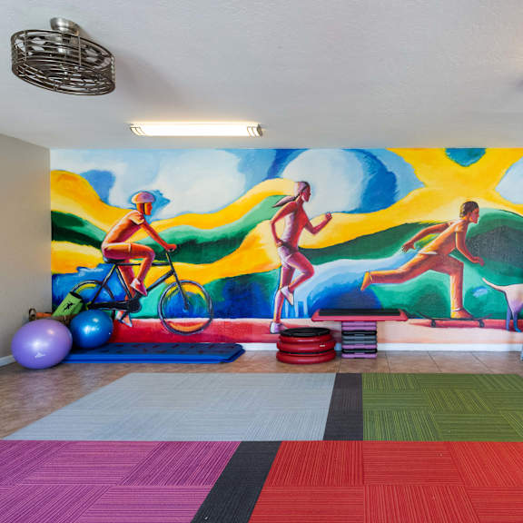 a wall mural in a room with a gym and exercise equipment
