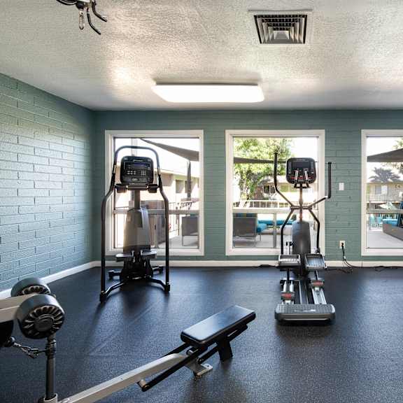 a gym with exercise equipment and windows at the resort at longboat key club