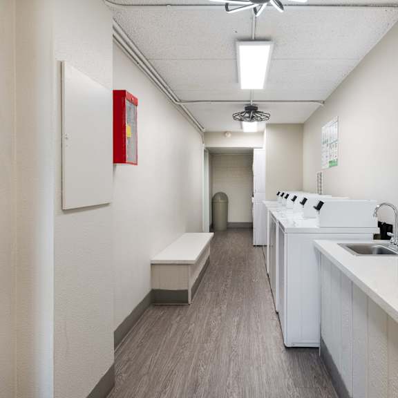 a long white room with a sink and a counter top