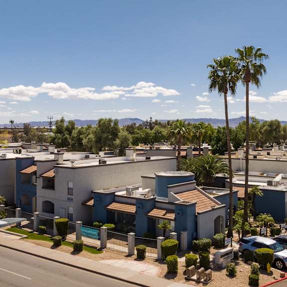an aerial view of a row of apartment buildings and palm trees