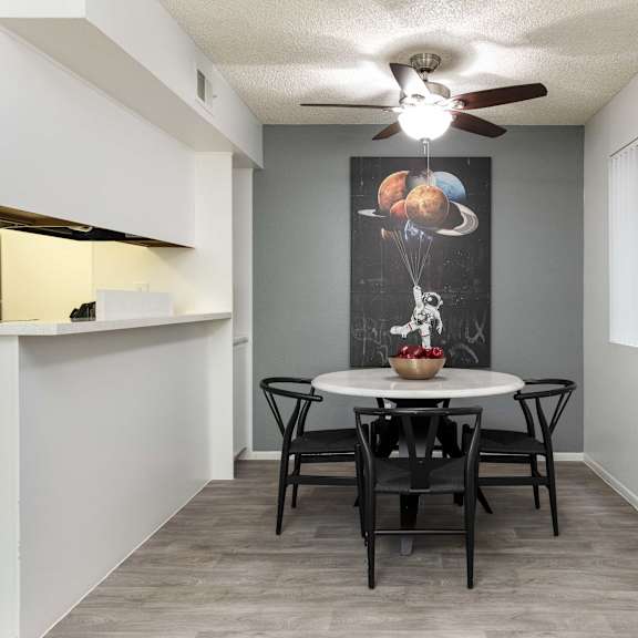 a dining room with a table and chairs and a ceiling fan