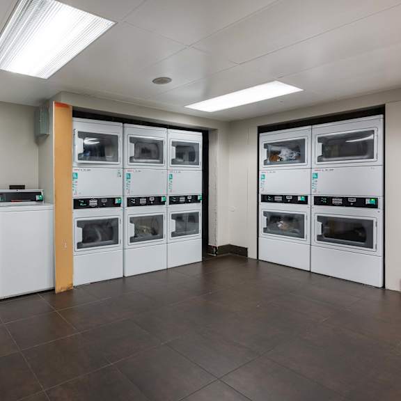 a laundry room with several washes and dryers in it