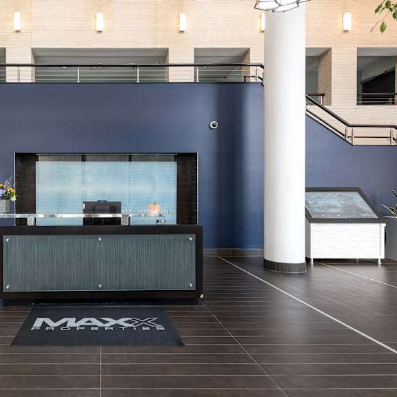a reception desk in a lobby with a blue wall and white pillars