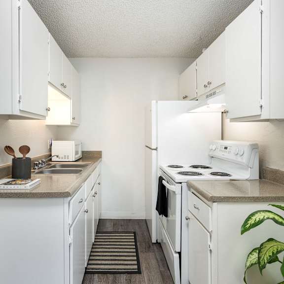 a kitchen with white appliances and counters and white cabinets