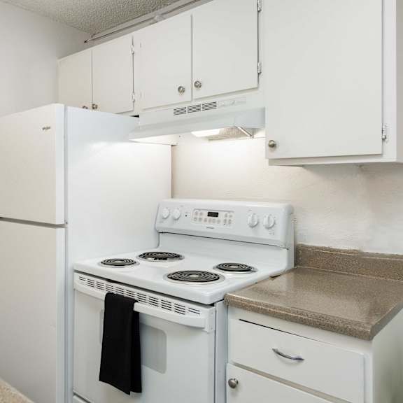 a kitchen with white appliances and white cabinets and a white refrigerator