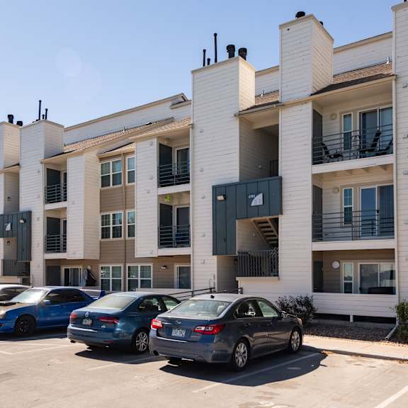 an apartment building with cars parked in front of it