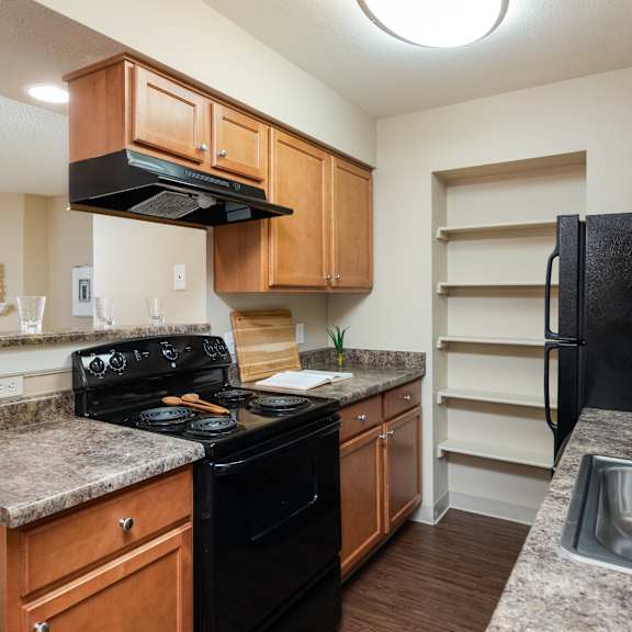 an updated kitchen with granite counter tops and black appliances
