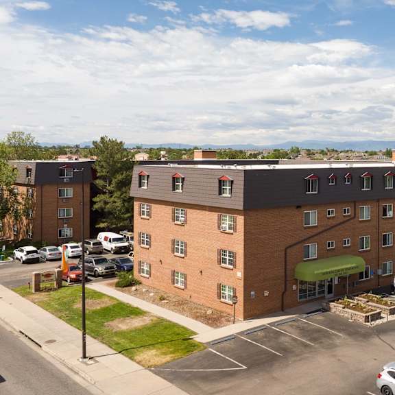 an aerial view of a building with a parking lot full of cars