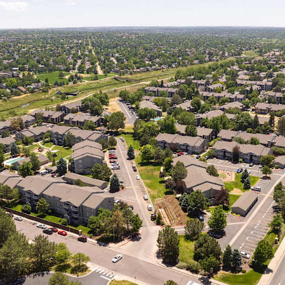 an aerial view of a suburban neighborhood with cars on the street and residential houses