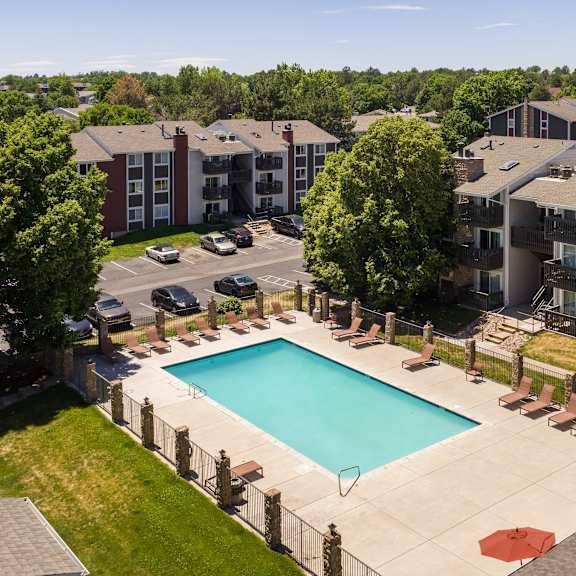 an aerial view of a swimming pool with apartments in the background