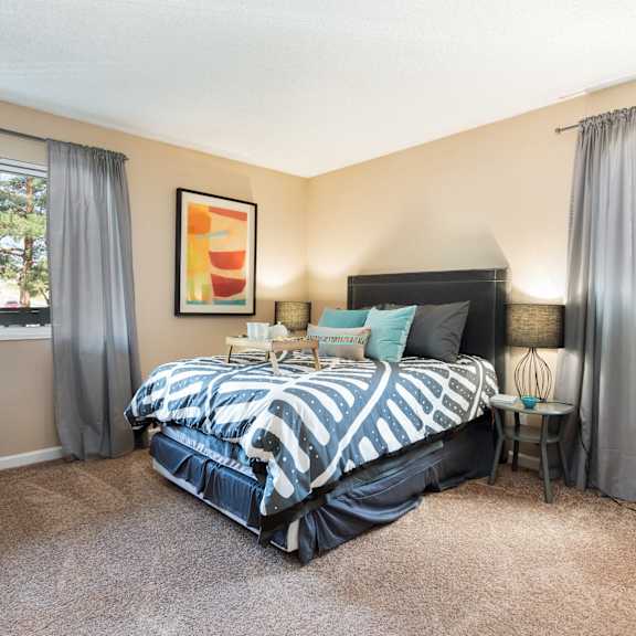 a bedroom with a bed and two windows