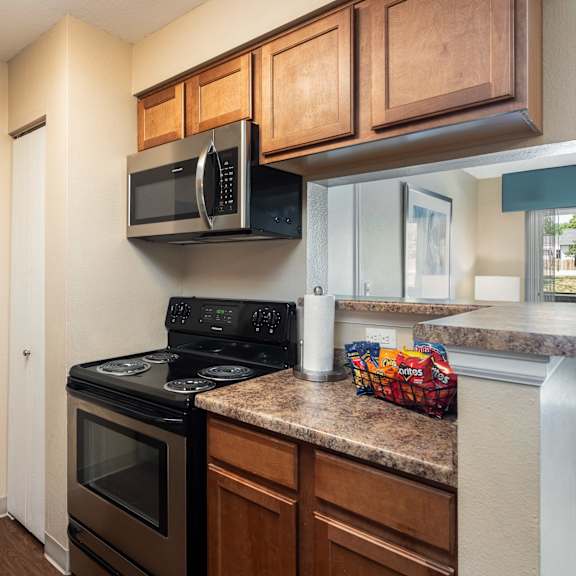 a kitchen with a stove and microwave and a counter with a sink