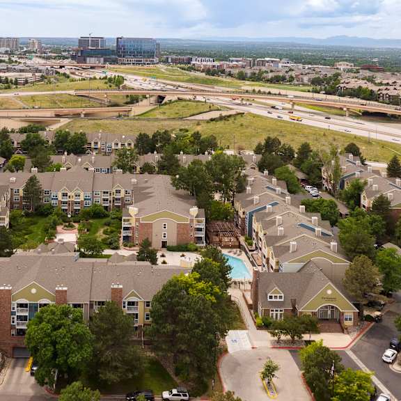 an aerial view of a neighborhood with houses and a city in the background