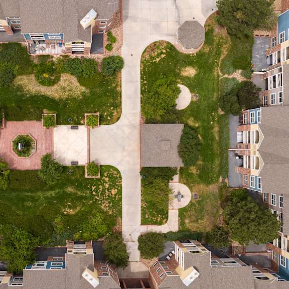 an aerial view of a building shaped like a face with grass and trees