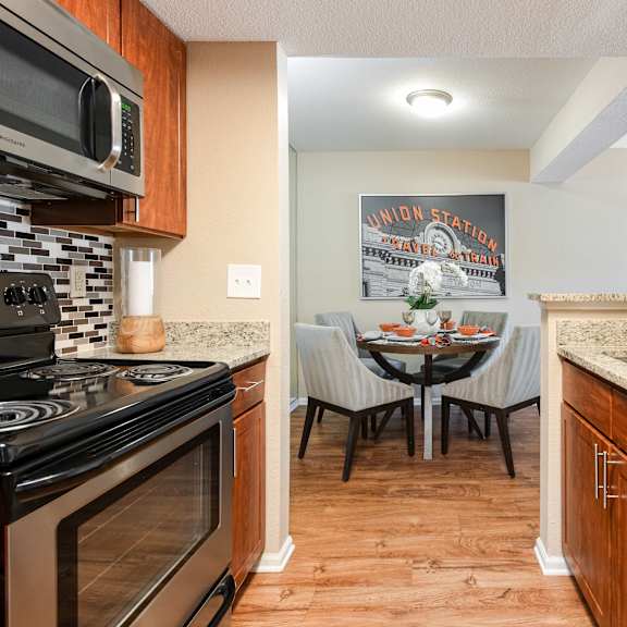 the kitchen and dining area of a home with a table and chairs