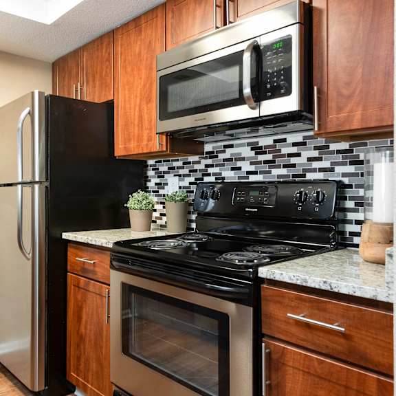 a kitchen with black appliances and a stainless steel refrigerator