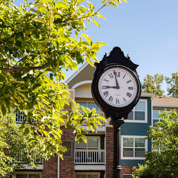 a clock on a pole in front of a building