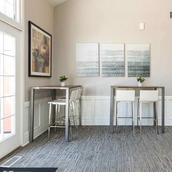 a living room with two bar stools in front of a window and a couch