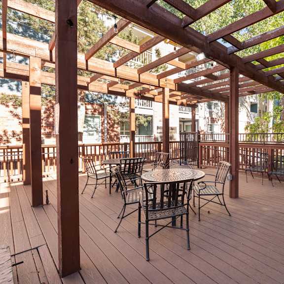 a patio with tables and chairs and a wooden deck
