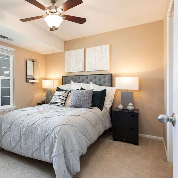 a bedroom with a large bed and a ceiling fan