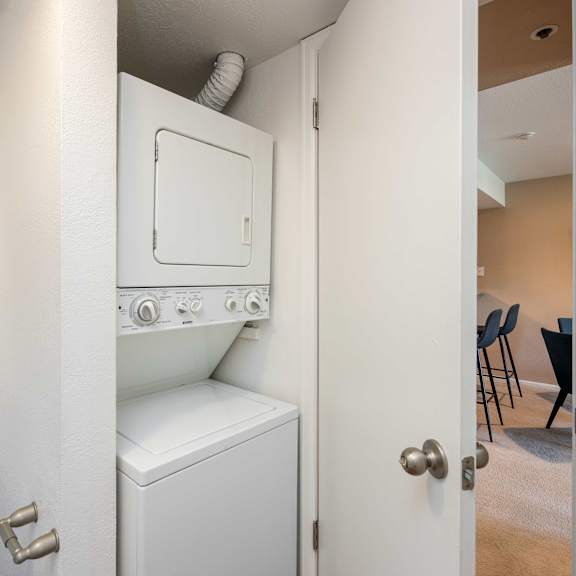 a washer and dryer in a small closet in a room with a door