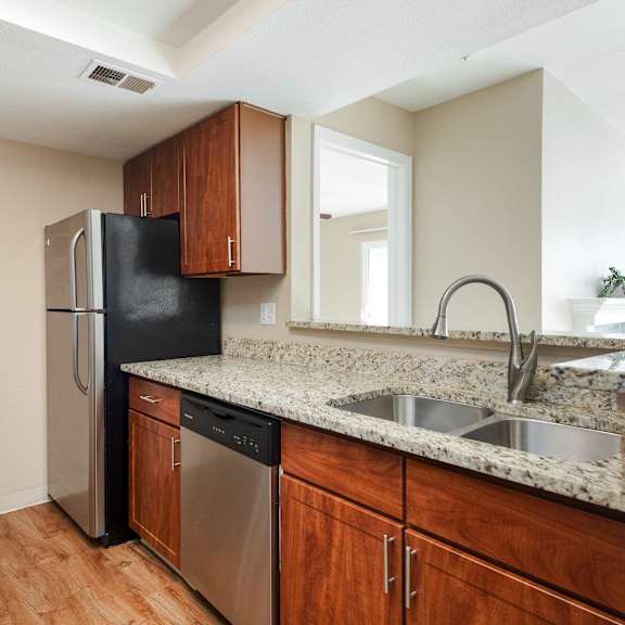 an empty kitchen with a stainless steel refrigerator and sink
