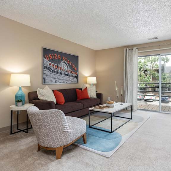 a living room with a couch and a table   and a balcony