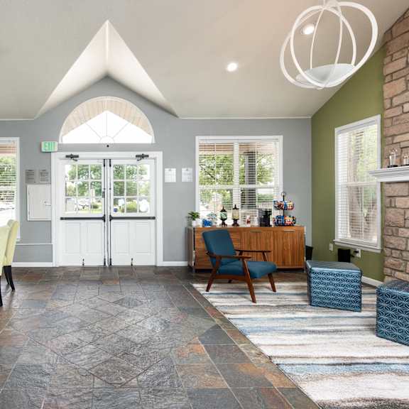 a reception area with a desk and chairs and a glass door