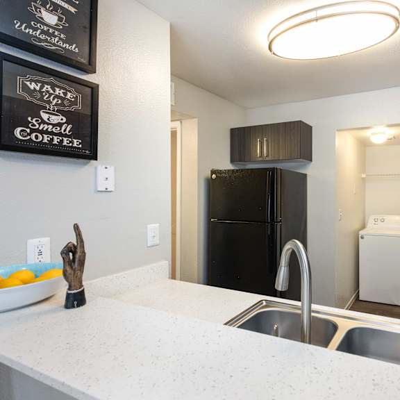 a kitchen with a sink and a counter and a refrigerator
