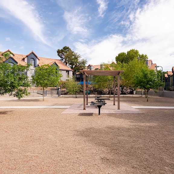 a park with a playground and trees with houses in the background