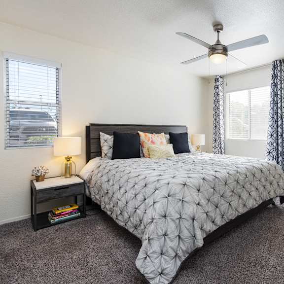 a bedroom with a bed and a ceiling fan